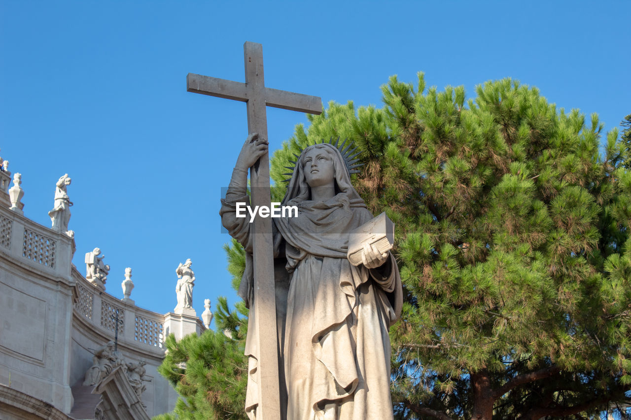 Low angle view of statue of a nun against sky