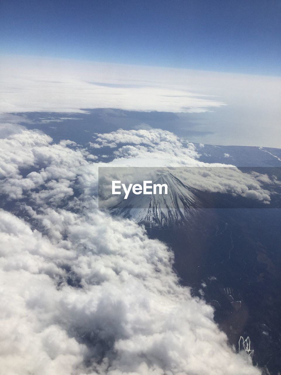 AERIAL VIEW OF MOUNTAINS AGAINST CLOUDY SKY
