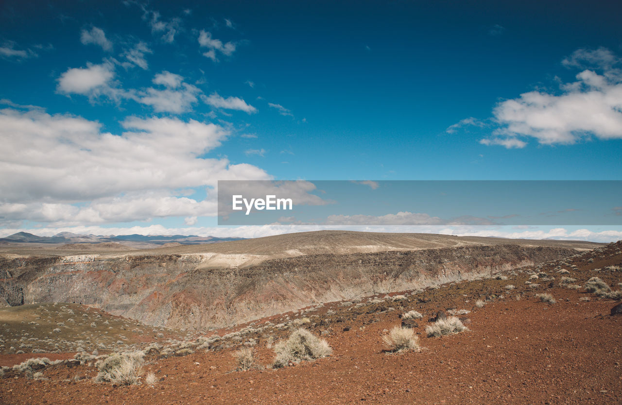 View of desert against cloudy sky
