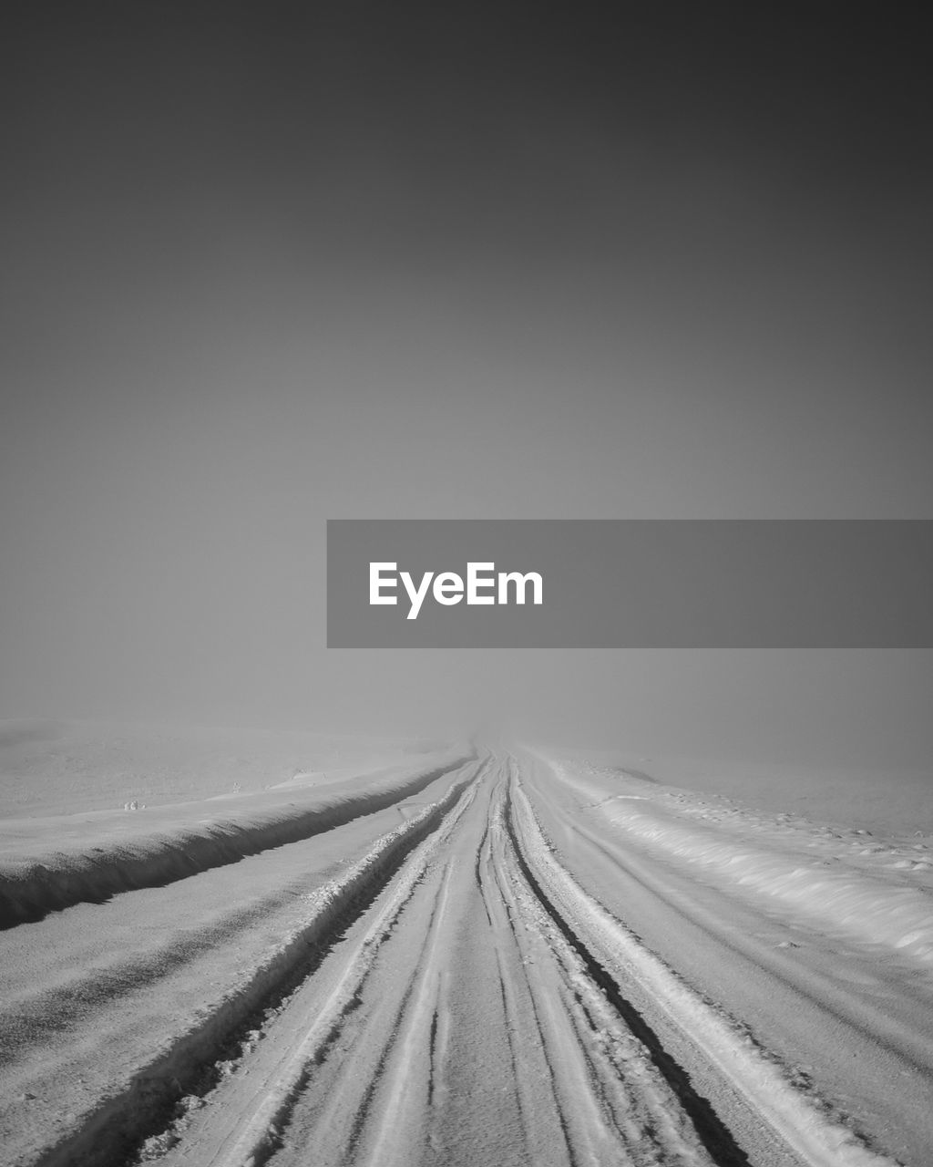 black and white, snow, transportation, monochrome, the way forward, horizon, monochrome photography, road, nature, sky, white, diminishing perspective, environment, vanishing point, no people, cold temperature, land, landscape, winter, scenics - nature, copy space, tire track, line, fog, tranquility, beauty in nature, tranquil scene, outdoors, day, travel, non-urban scene, field