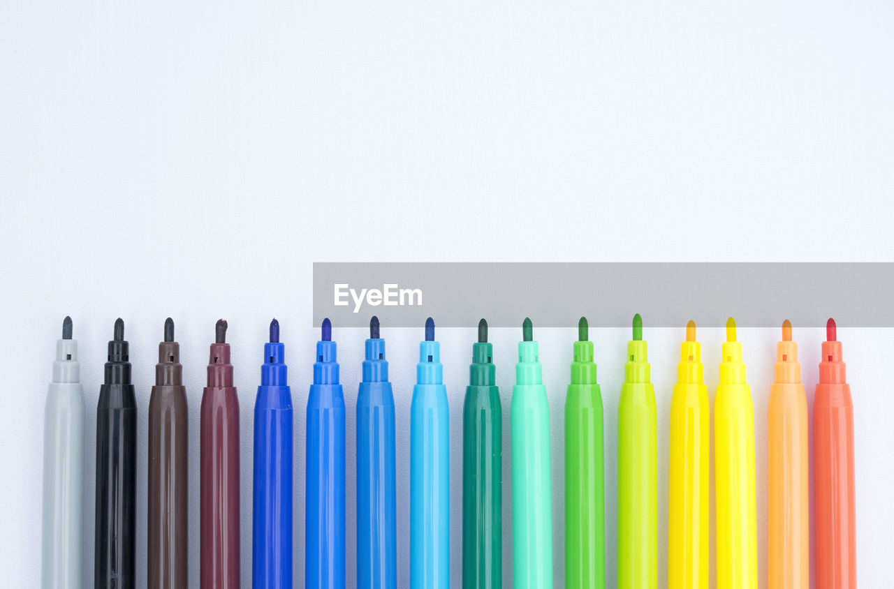 Close-up of colored markers against white background
