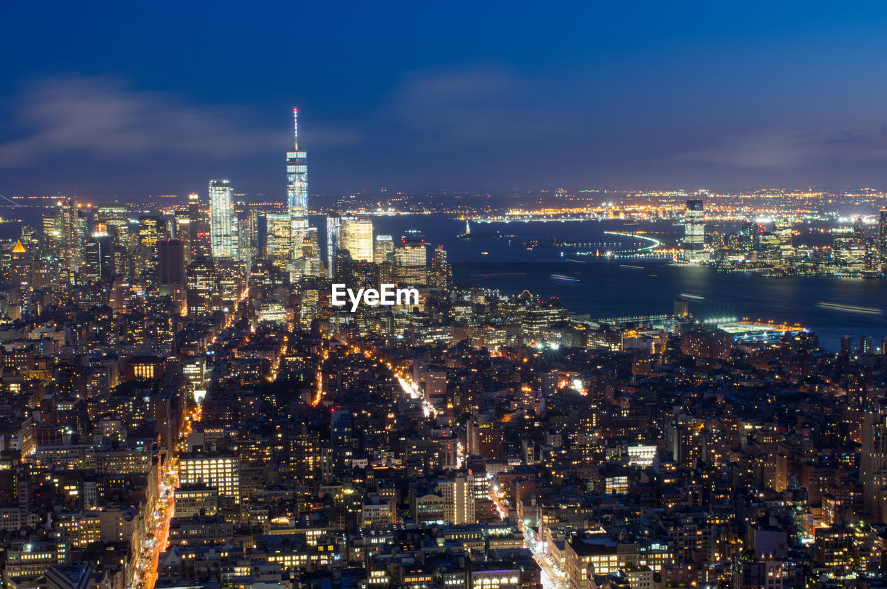 Illuminated cityscape against sky at night