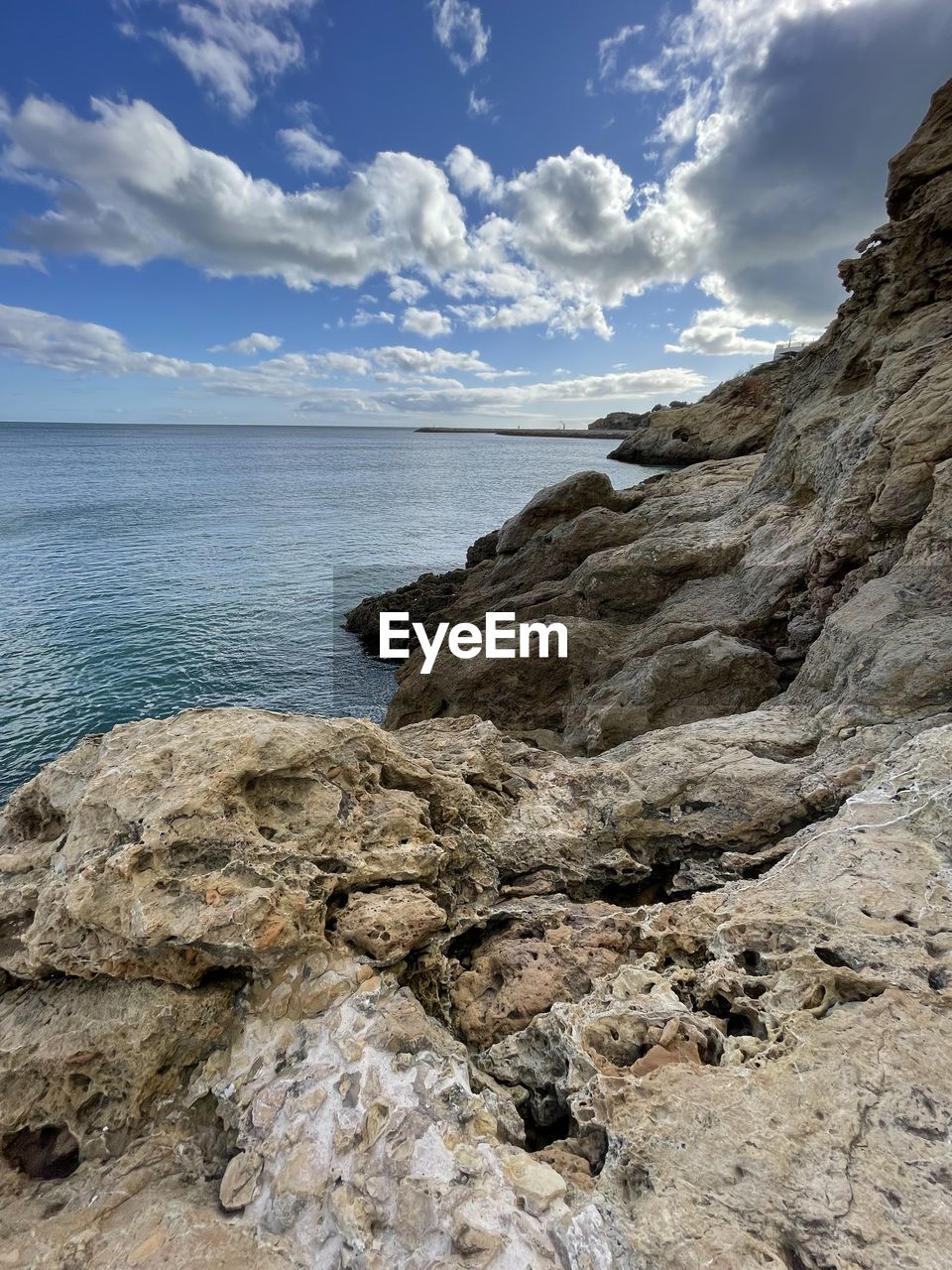 cloud, nature, rock, sky, rock formation, water, beauty in nature, no people, scenics - nature, day, outdoors, geology, cliff, tranquility, land, formation, cave, environment, physical geography, terrain, sea, mountain, travel, blue, beach, non-urban scene, low angle view, travel destinations, landscape