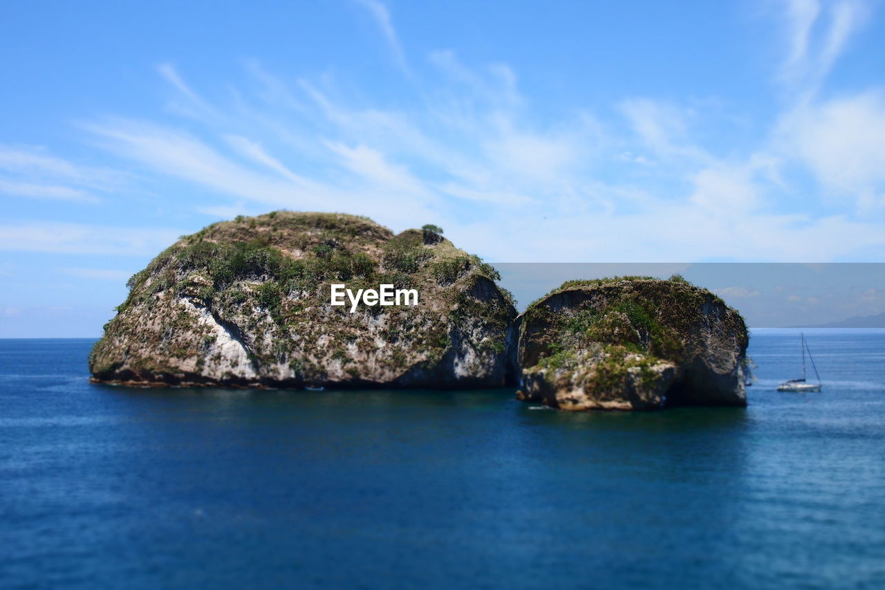 Rock formation in sea against sky