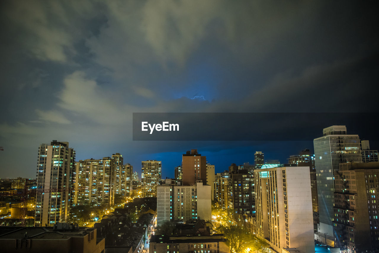 Illuminated cityscape against sky at night