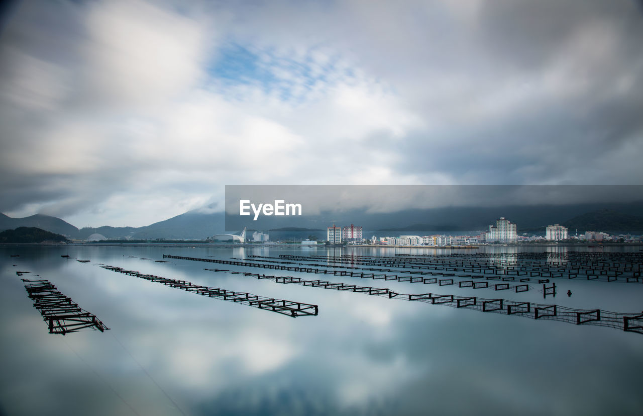 Scenic view of calm lake against cloudy sky 