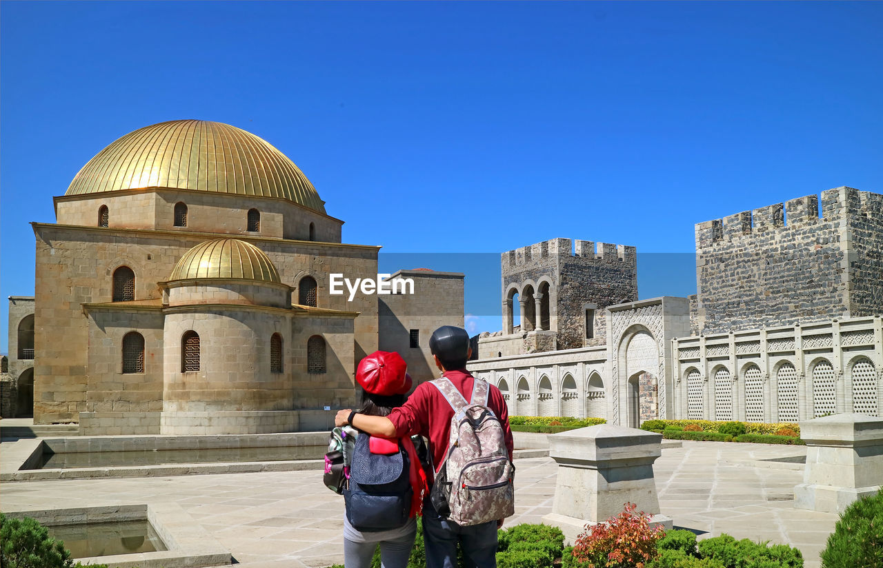 Couple admiring gorgeous akhmediye mosque, an outstanding building inside the rabati fort, georgia