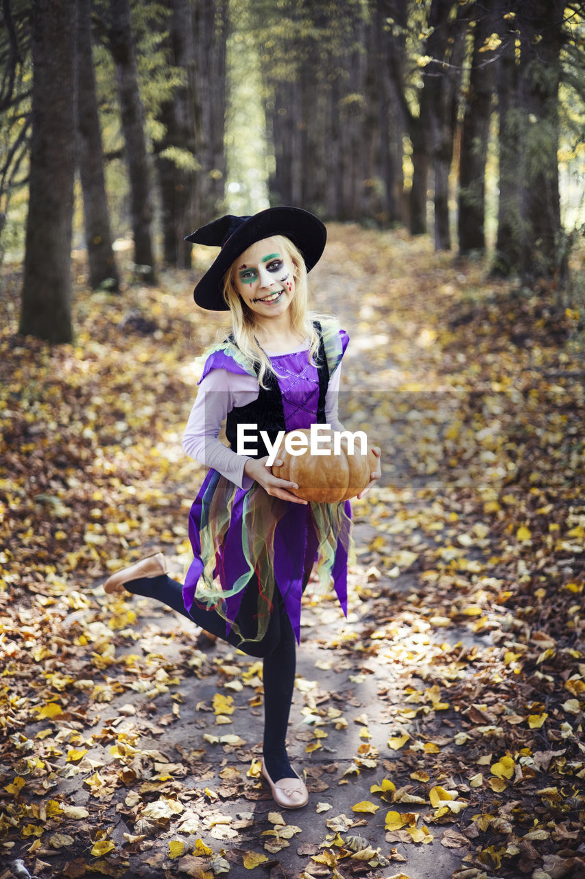 Full length of halloween girl standing in forest