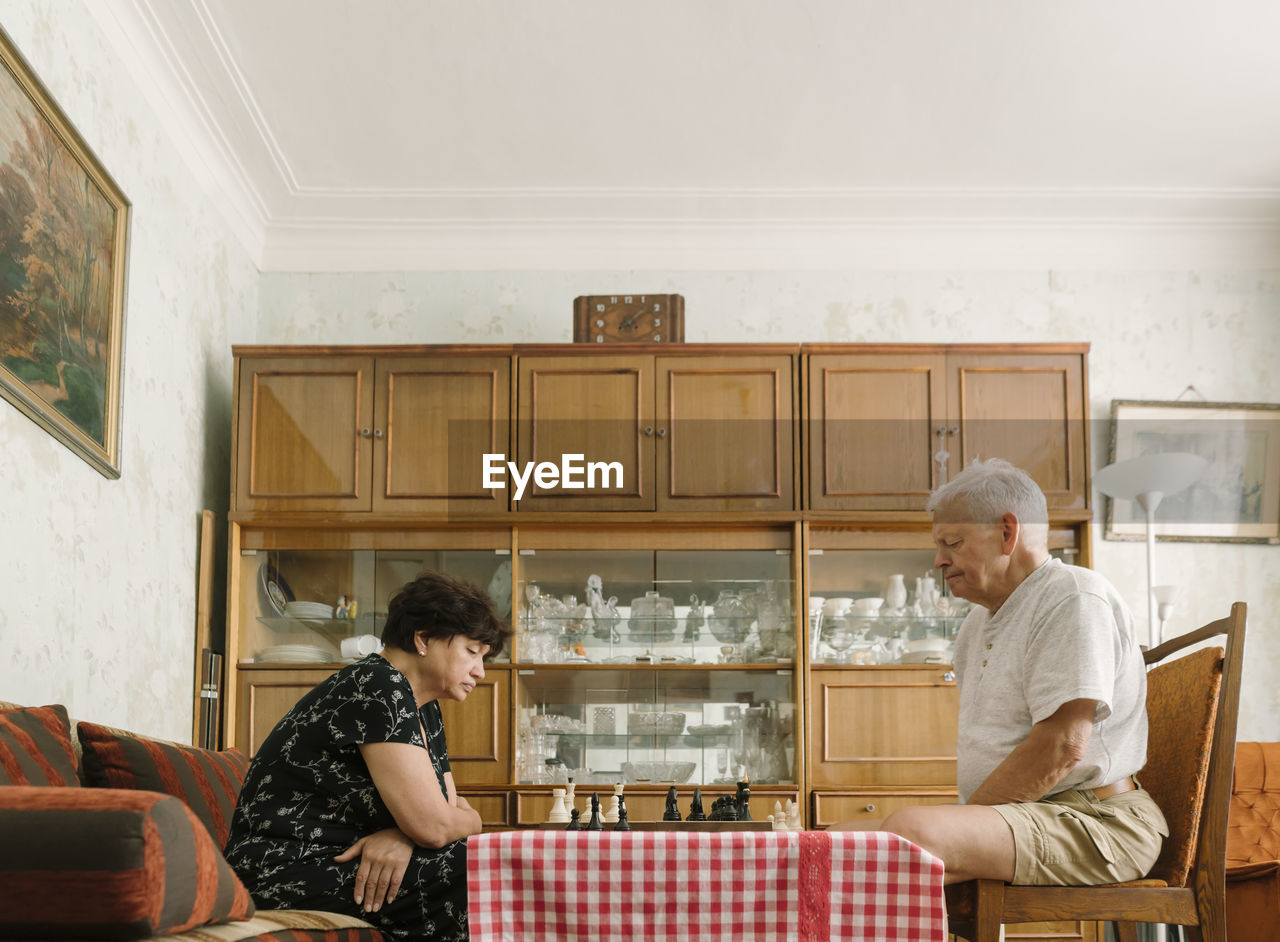 Senior couple playing chess at home