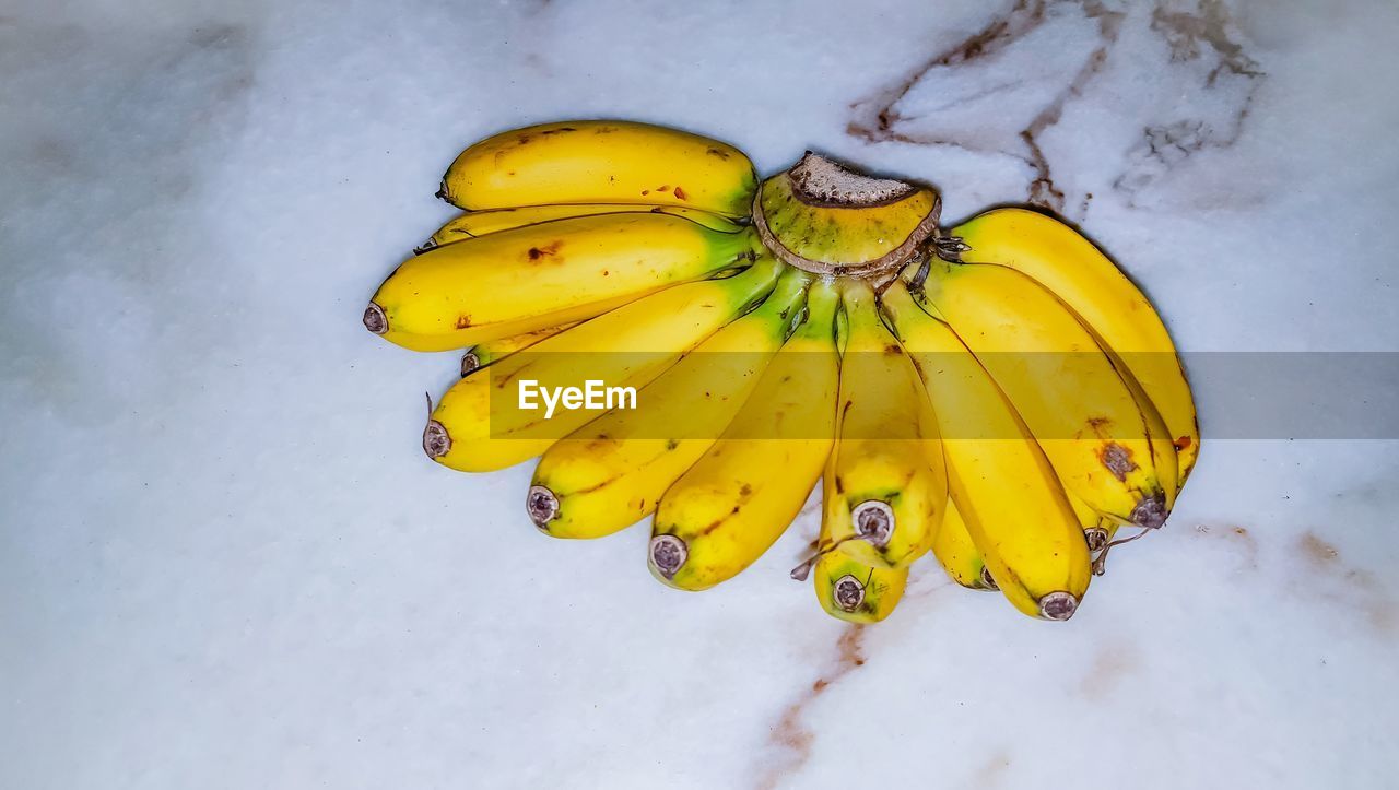 HIGH ANGLE VIEW OF YELLOW FRUIT ON WHITE