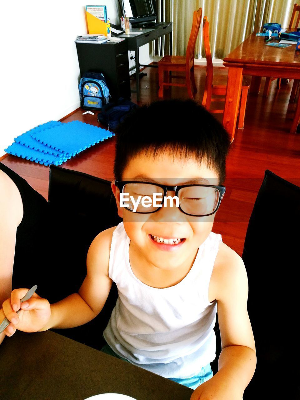 PORTRAIT OF SMILING YOUNG MAN IN EYEGLASSES