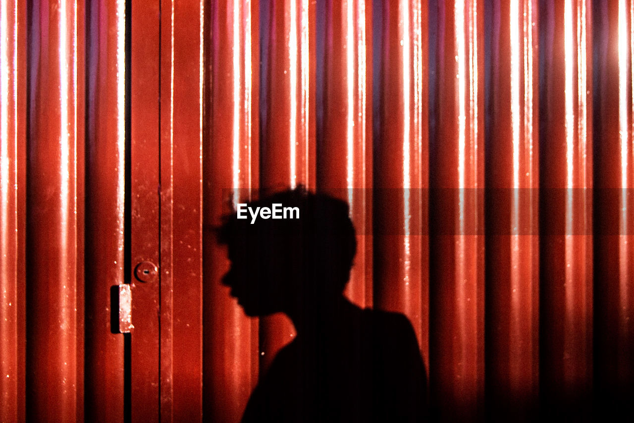 Shadow of man on brown corrugated iron