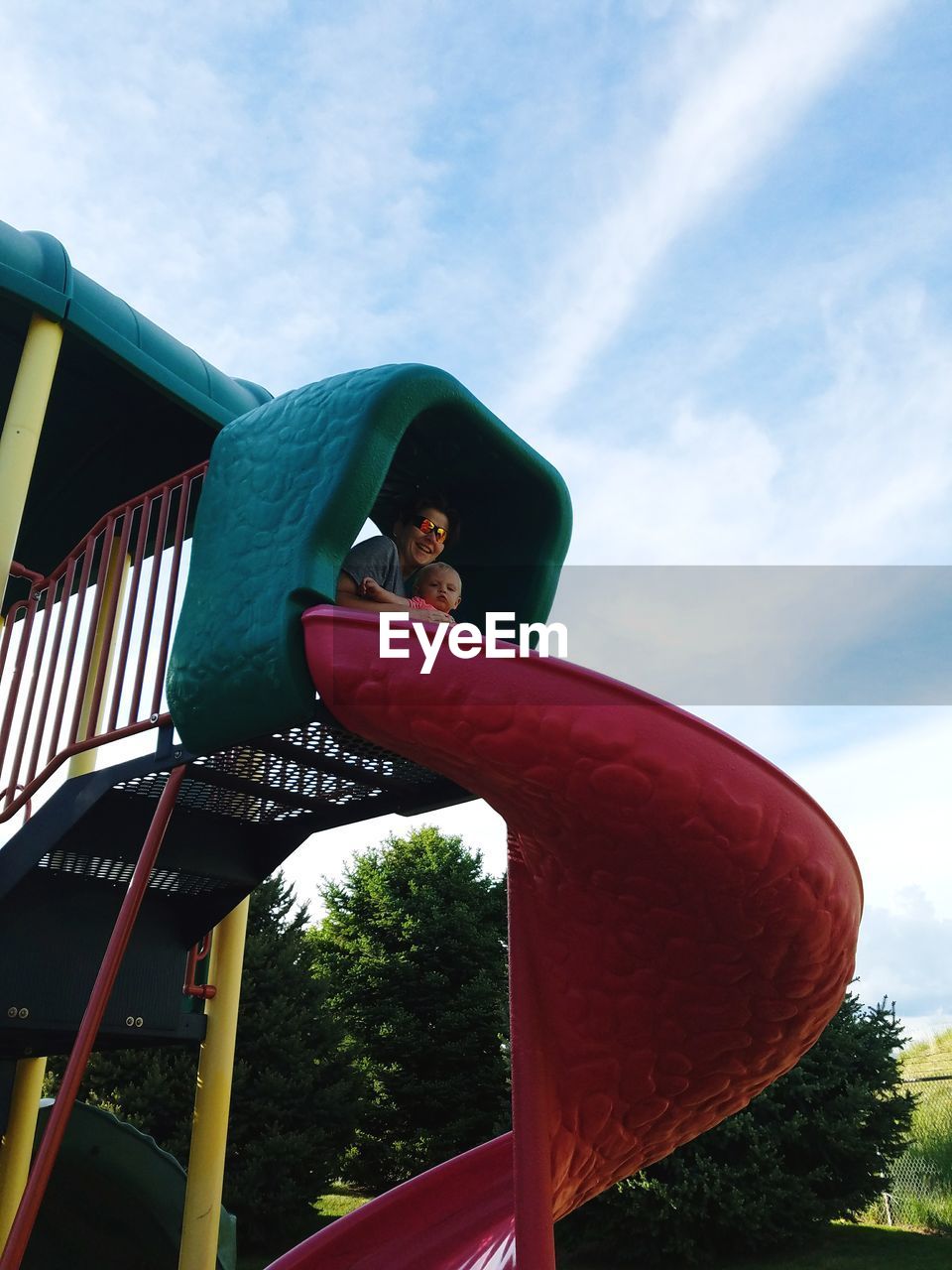 Low angle view of mother with baby boy in slide