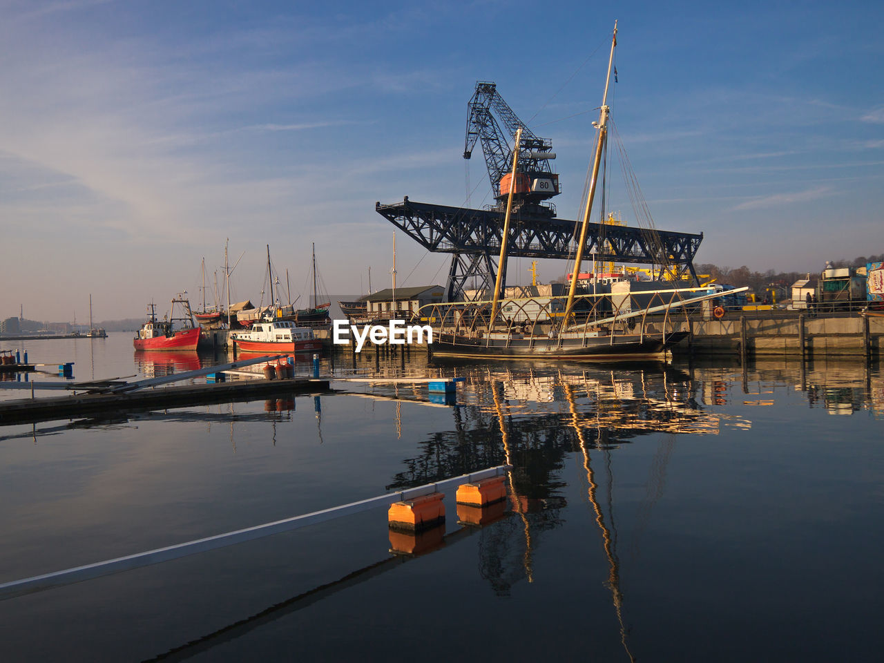 Crane at harbor against sky