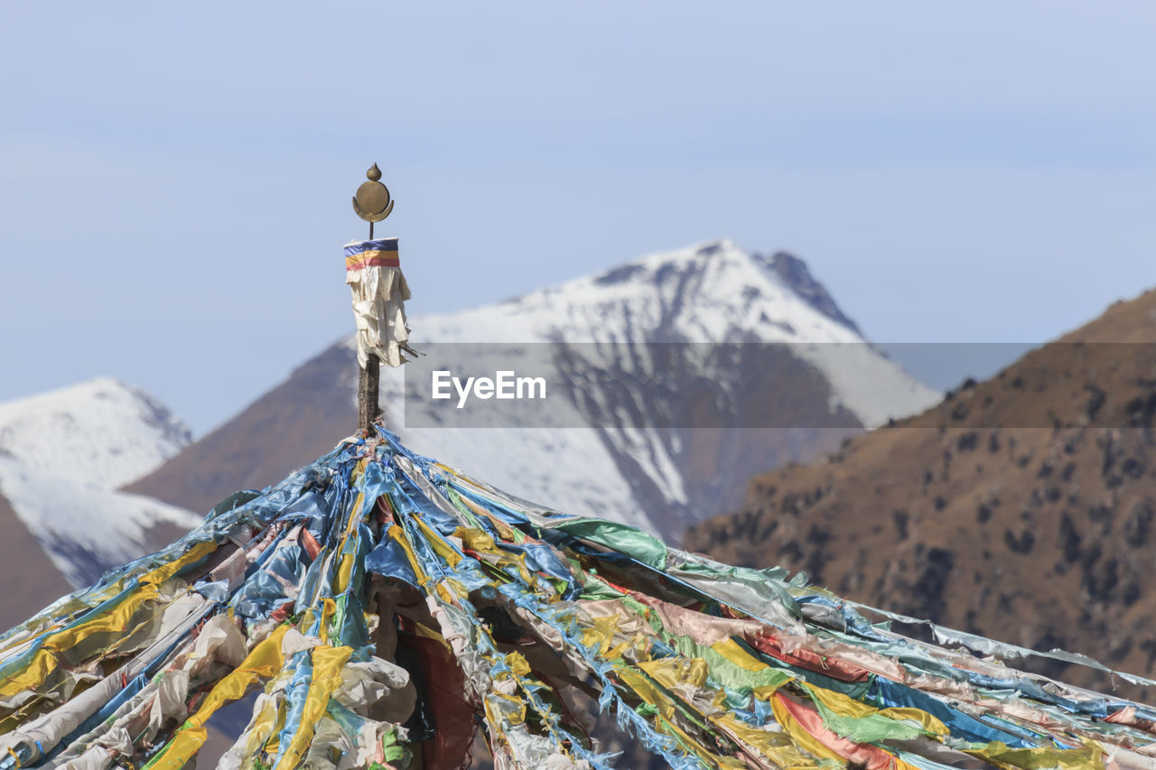 Close-up of prayer flags on mountain against clear sky