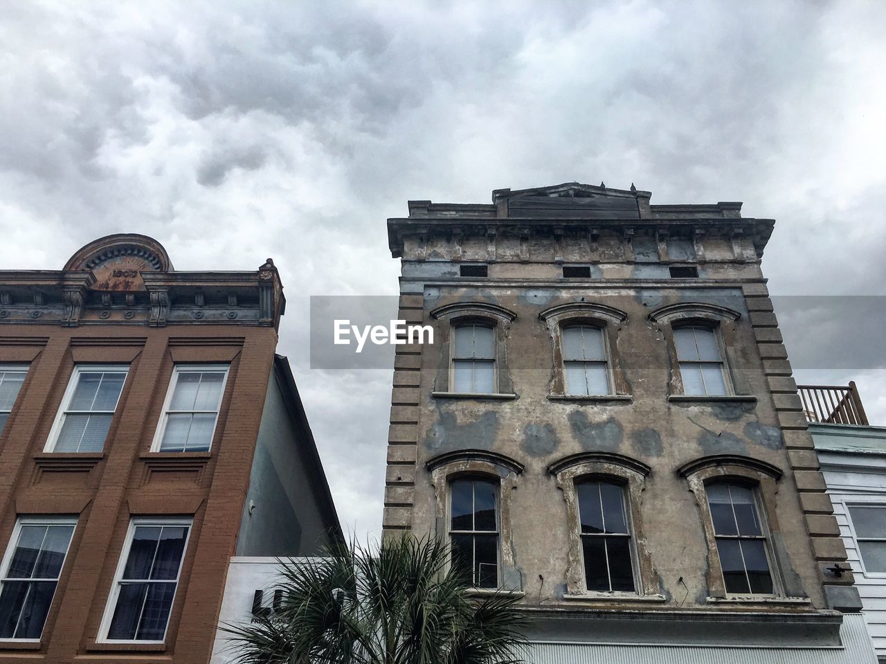 LOW ANGLE VIEW OF BUILDINGS AGAINST CLOUDY SKY