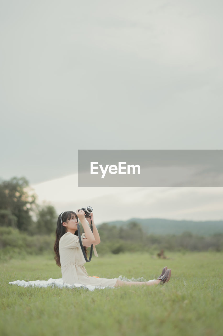bride, wedding dress, adult, women, nature, copy space, grass, sky, plant, young adult, one person, female, emotion, day, landscape, land, field, outdoors, love, environment, standing, positive emotion, clothing, animal, leisure activity, activity, men, animal themes, mammal, looking, rural scene, side view, happiness, beauty in nature, selective focus, holding, plain