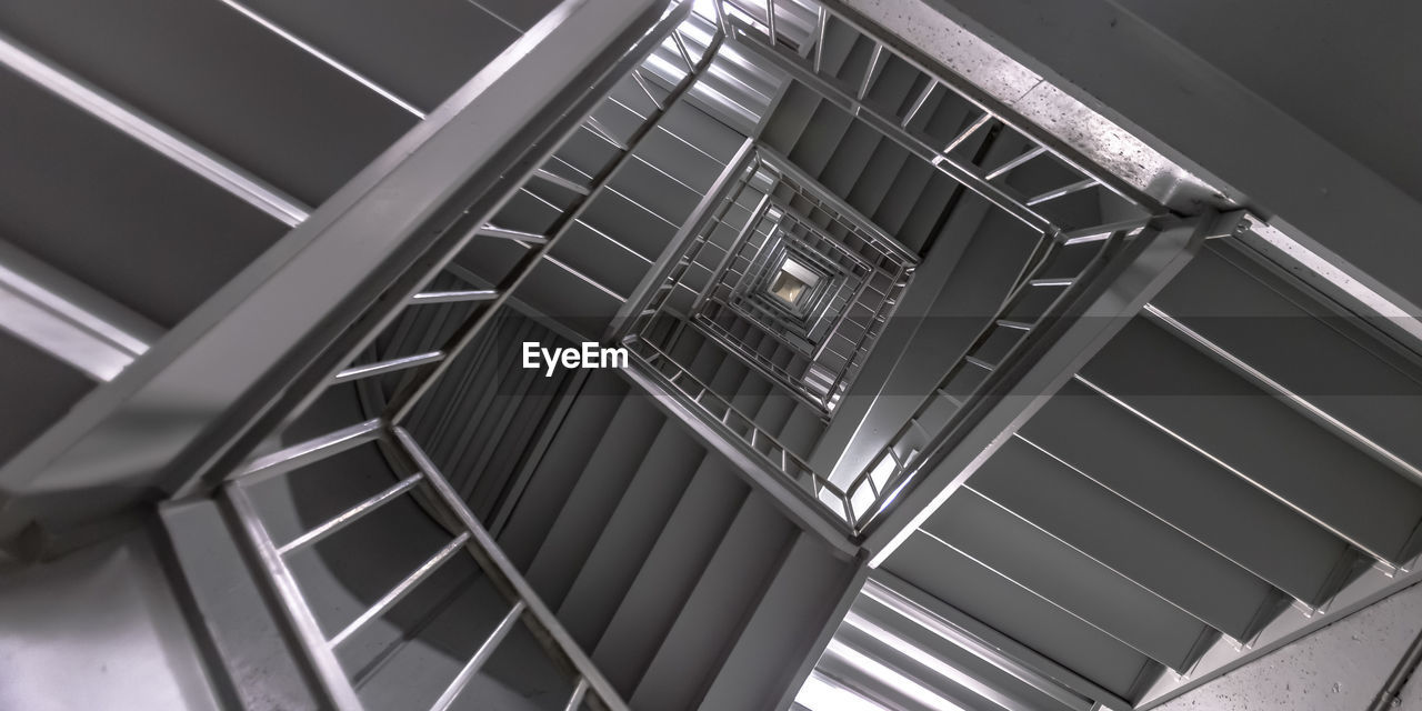LOW ANGLE VIEW OF SPIRAL STAIRCASE IN MODERN BUILDING