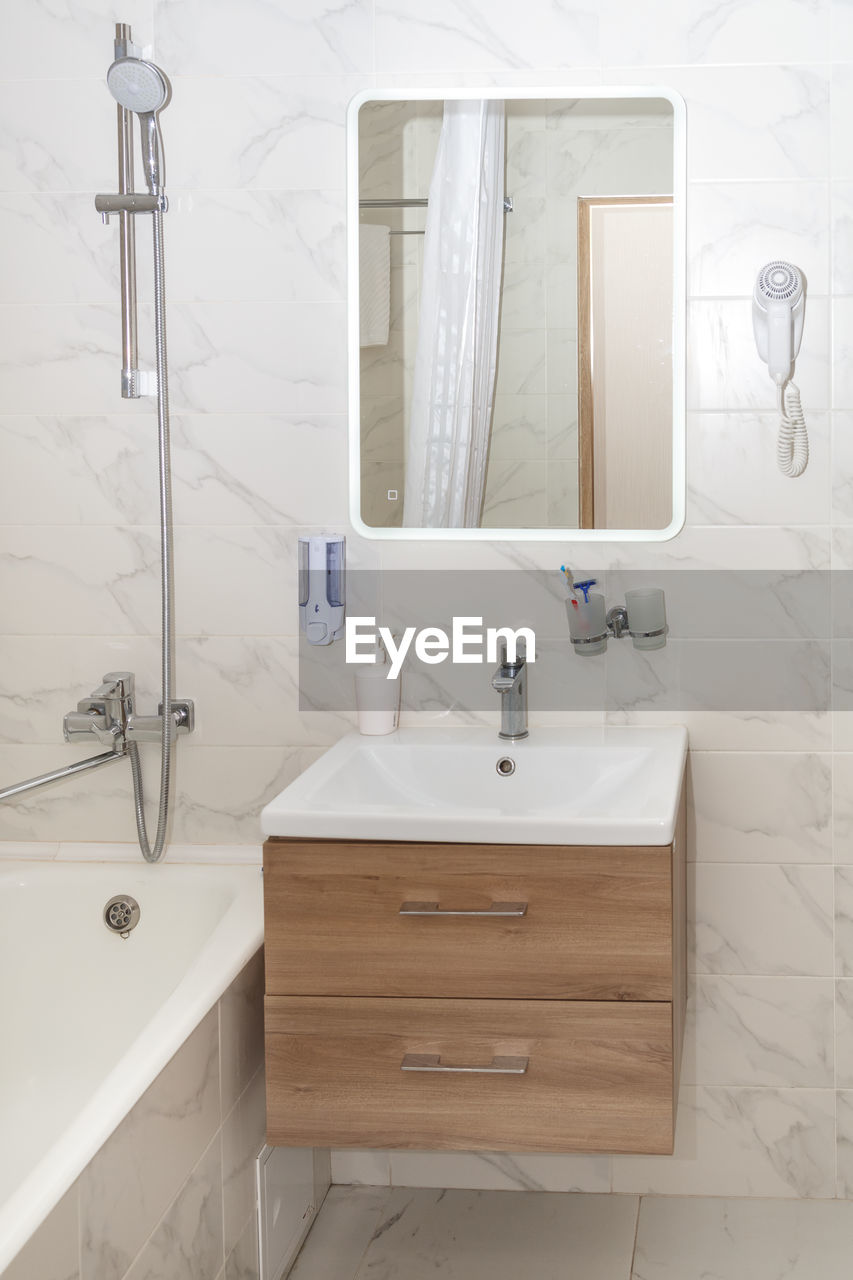 bathroom, sink, home, domestic bathroom, domestic room, faucet, indoors, mirror, bathroom cabinet, home interior, hygiene, household equipment, plumbing fixture, no people, tap, bathroom sink, shower, floor, drawer, room, flooring, bathroom accessory, luxury, white, home showcase interior, furniture, towel, wealth, reflection