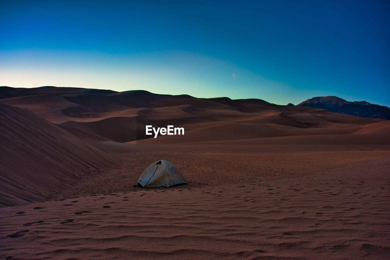 Scenic view of tent in sand dunes