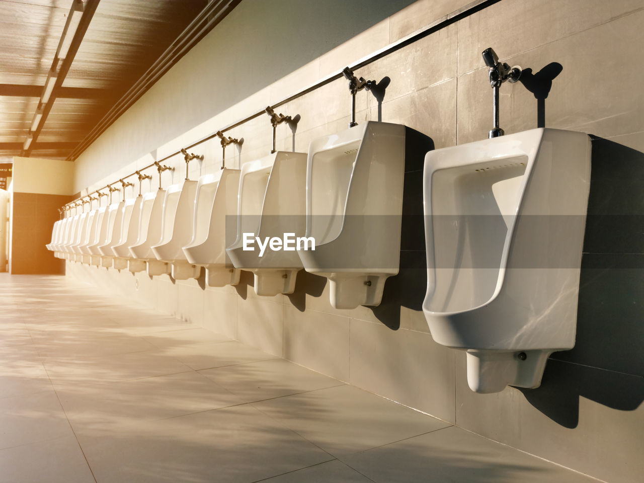 Row of white urinals in public toilets, selective focus