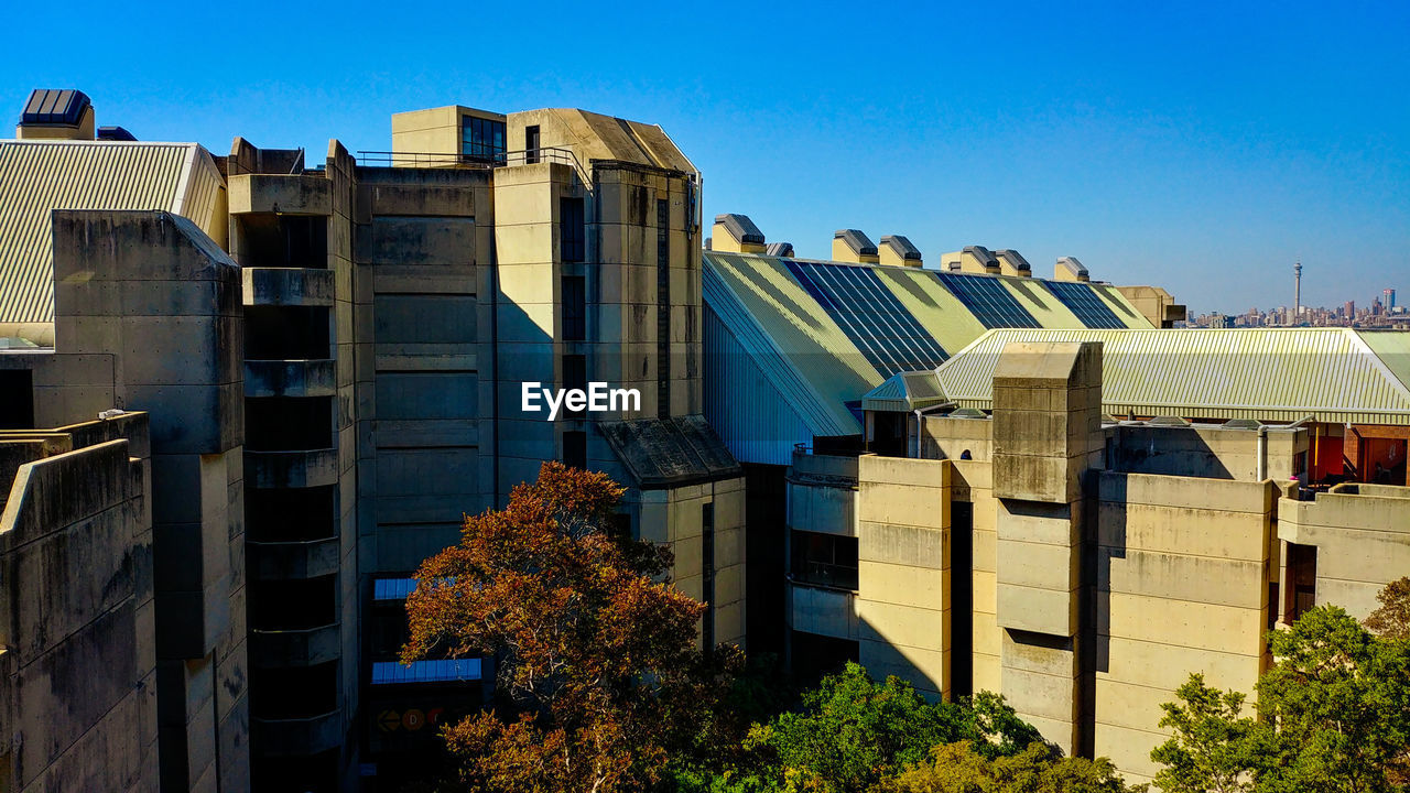 LOW ANGLE VIEW OF BUILDINGS AGAINST BLUE SKY