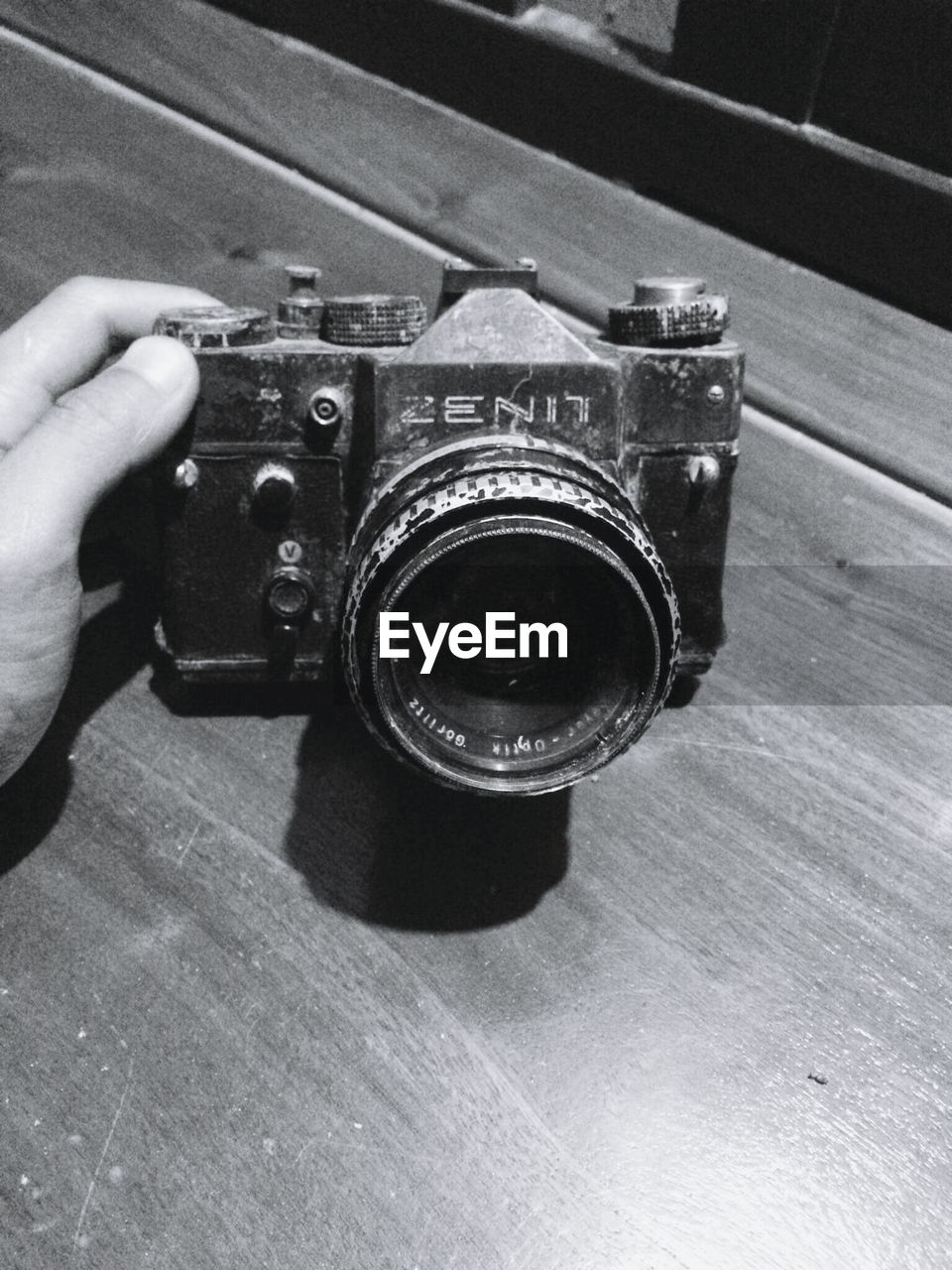 CLOSE-UP OF HAND HOLDING CAMERA ON MIRROR