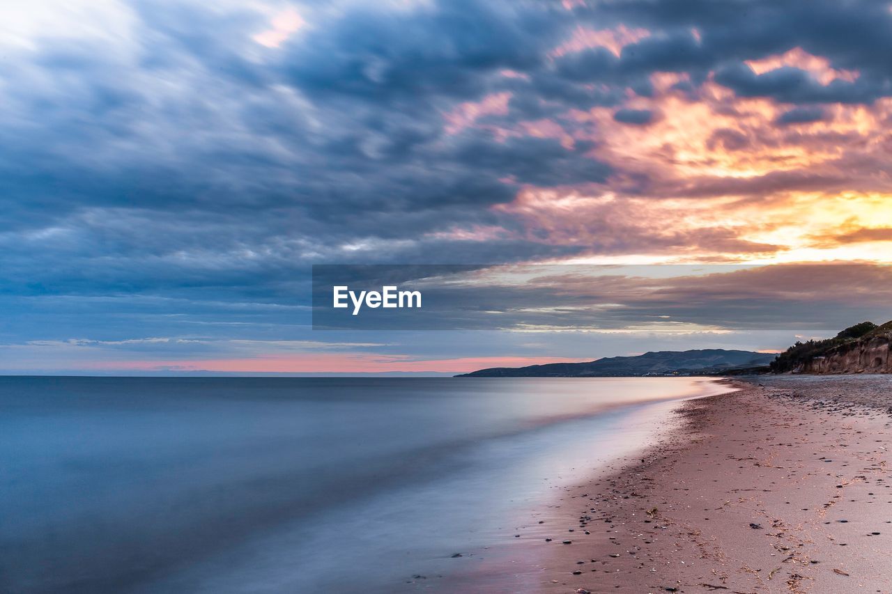 Scenic view of beach against sky during sunset