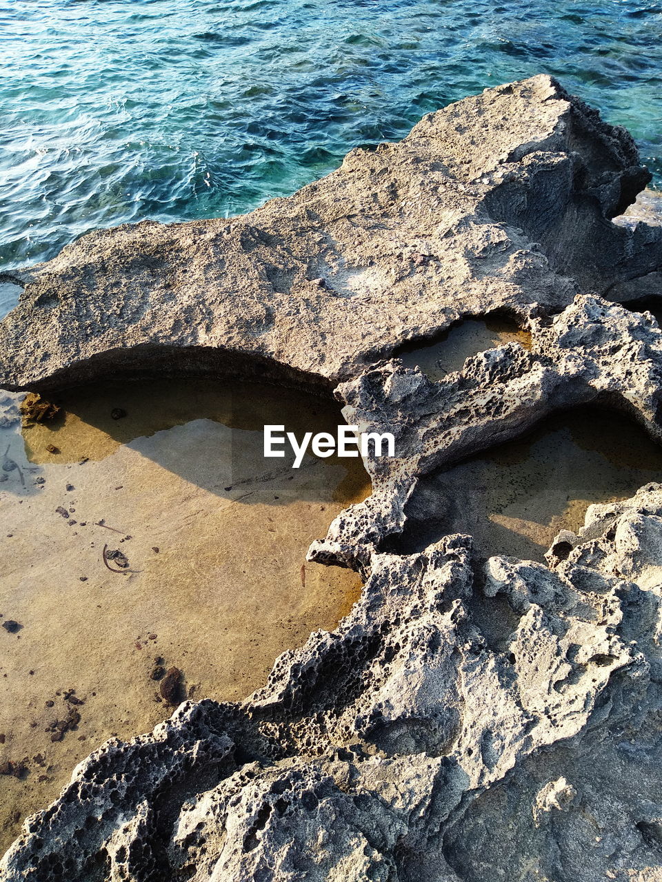 HIGH ANGLE VIEW OF ROCKS ON SHORE