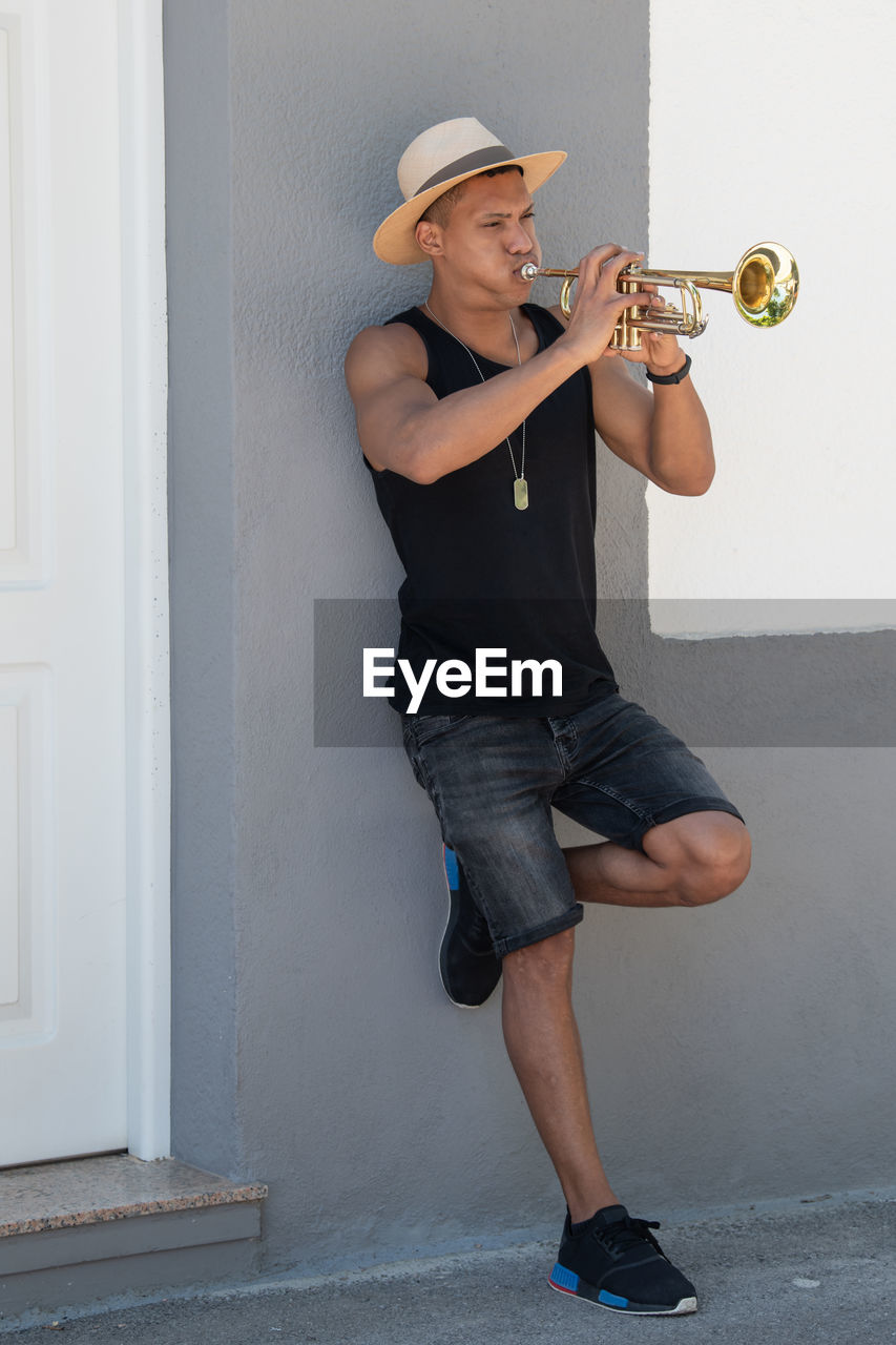 Full length of man playing trumpet