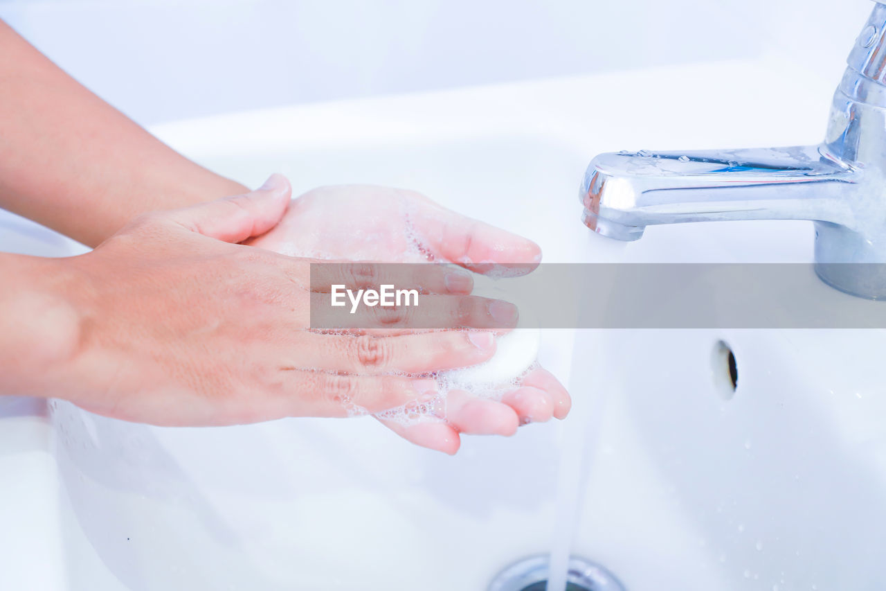 CLOSE-UP OF HAND HOLDING WATER