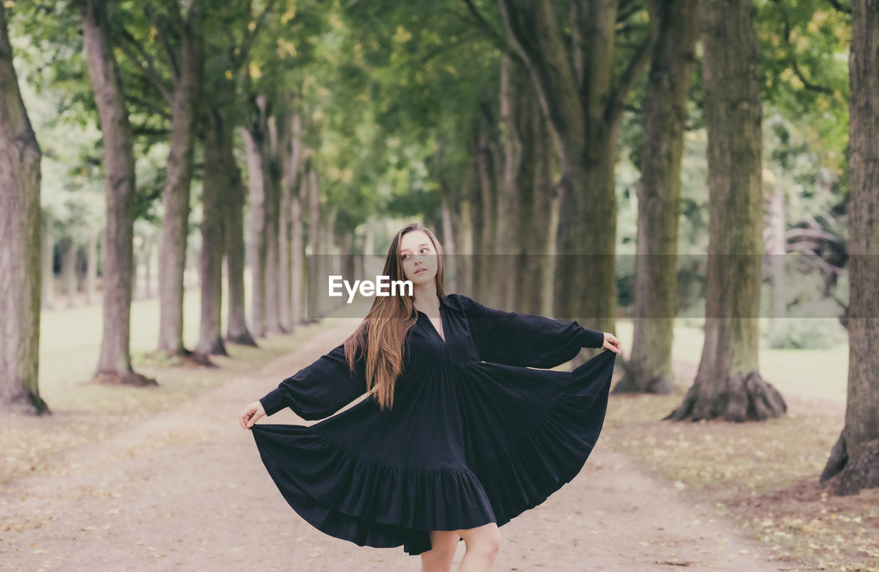 Young woman wearing dress standing in park