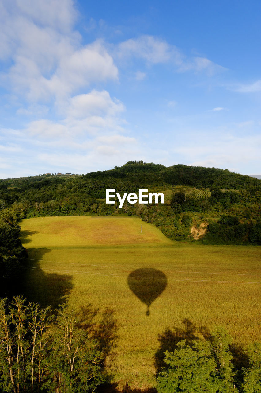 Scenic view of field against sky with balloon shade 