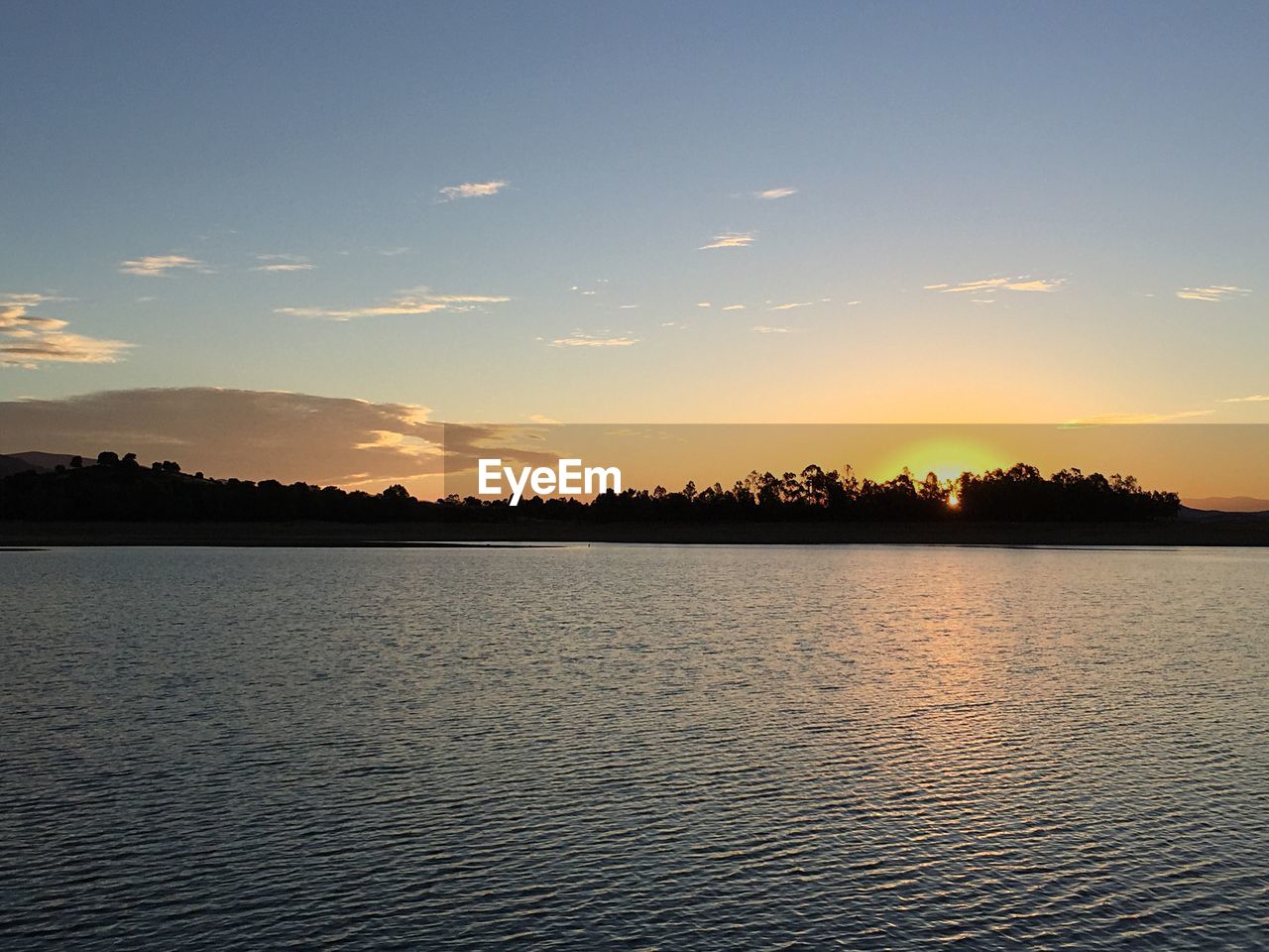 SCENIC VIEW OF LAKE BY SILHOUETTE TREES AGAINST SKY DURING SUNSET