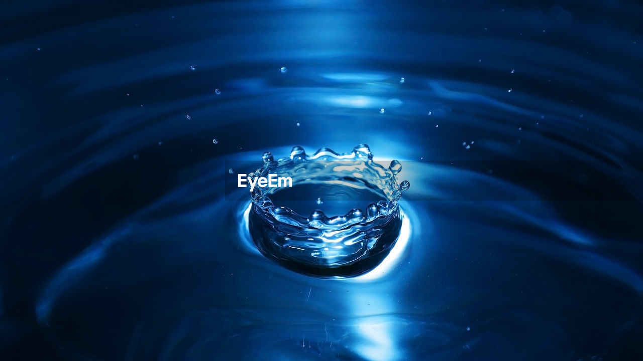 CLOSE-UP OF WATER DROP ON BLUE RIPPLED