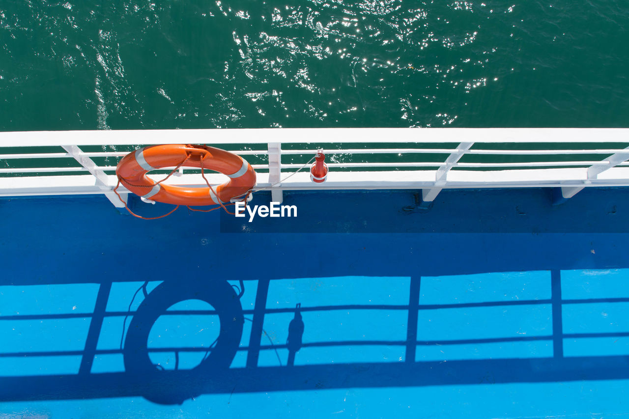 HIGH ANGLE VIEW OF BOAT ON BLUE WATER