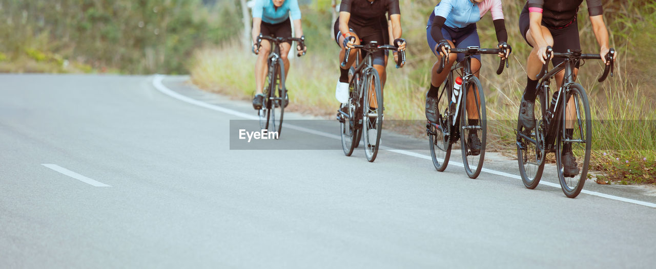 Low section of people riding bicycle on road