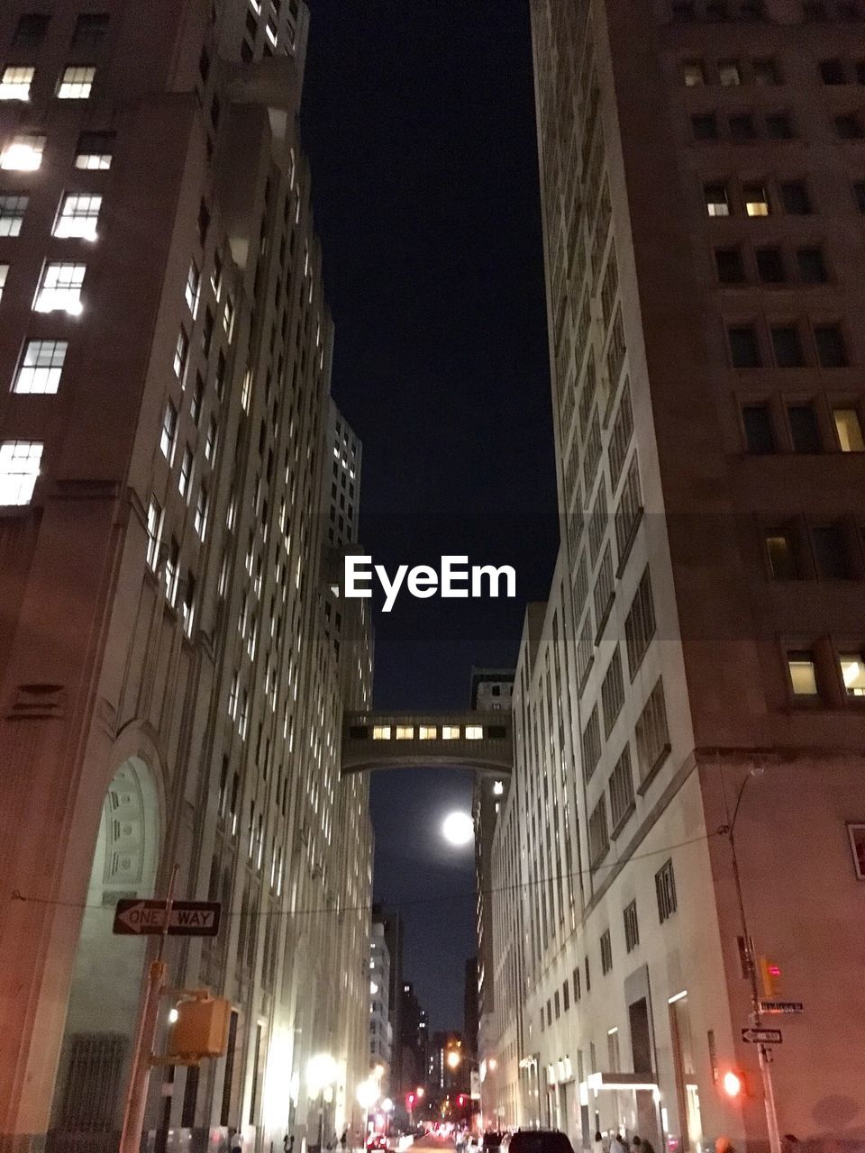 LOW ANGLE VIEW OF ILLUMINATED CITY STREET AT NIGHT