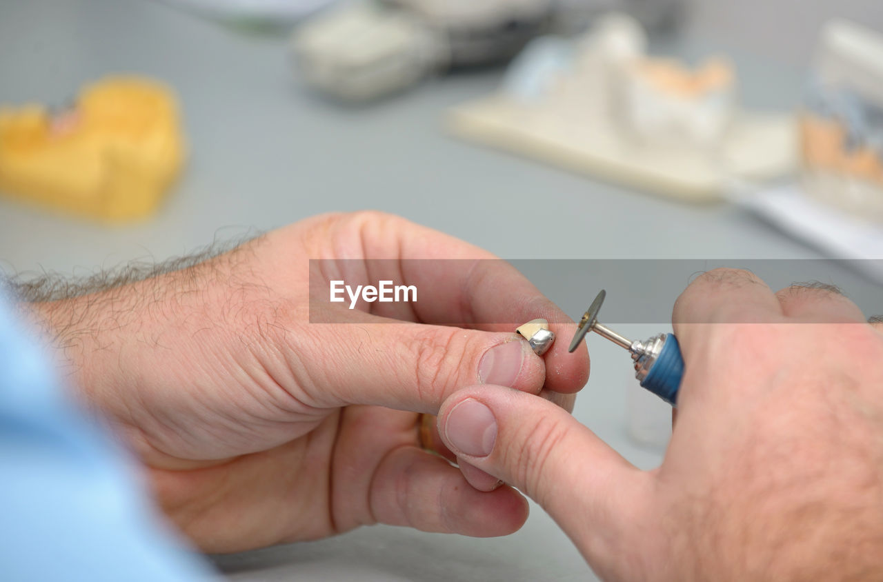 Cropped hands of male dental technician working in laboratory