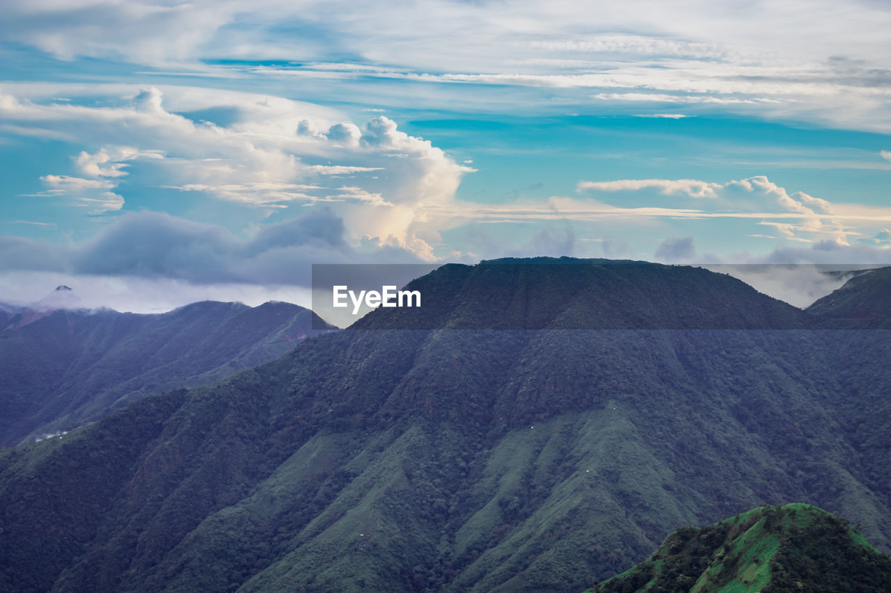 Mountain range with dramatic sunset sky and low clouds at evening