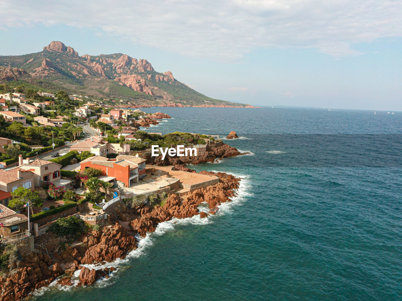 Scenic view of sea by buildings against sky