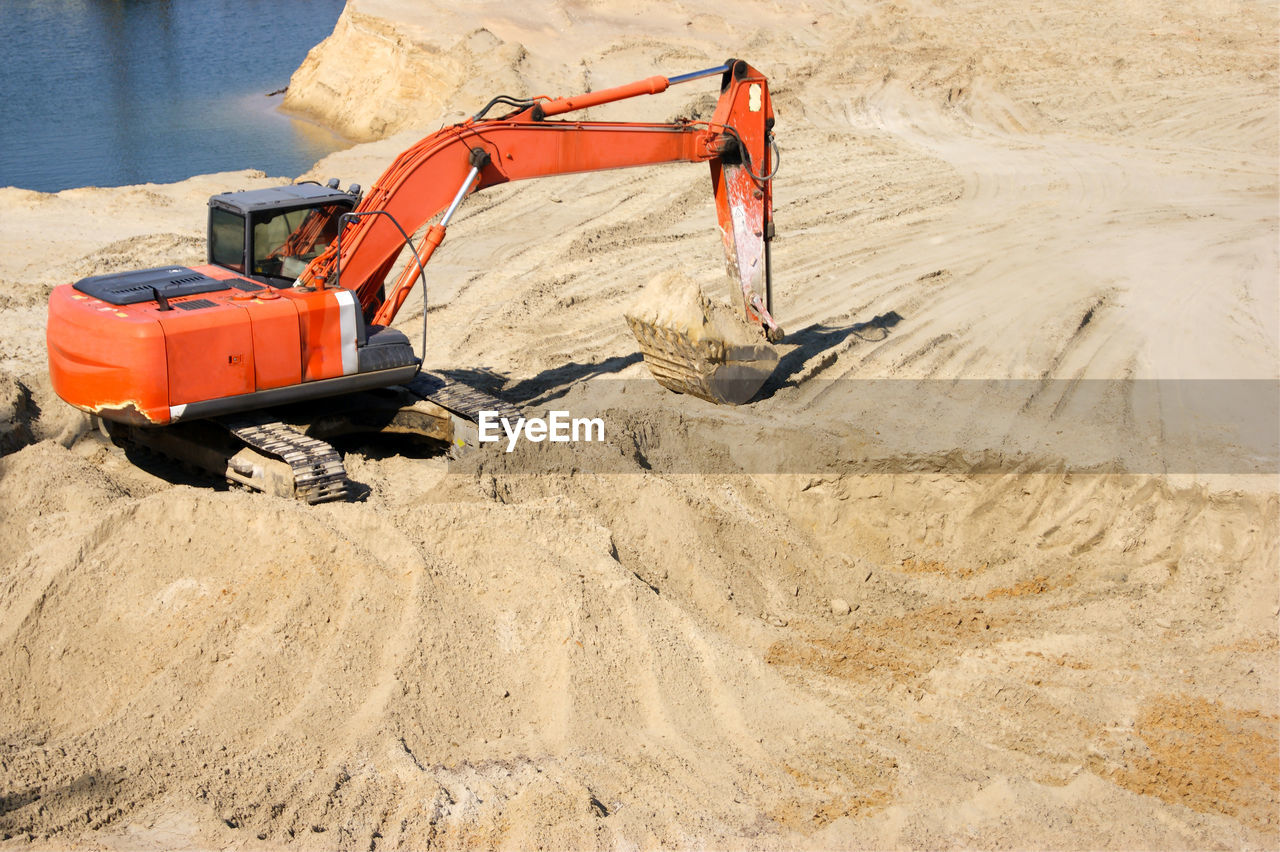 low section of man standing on sand at beach