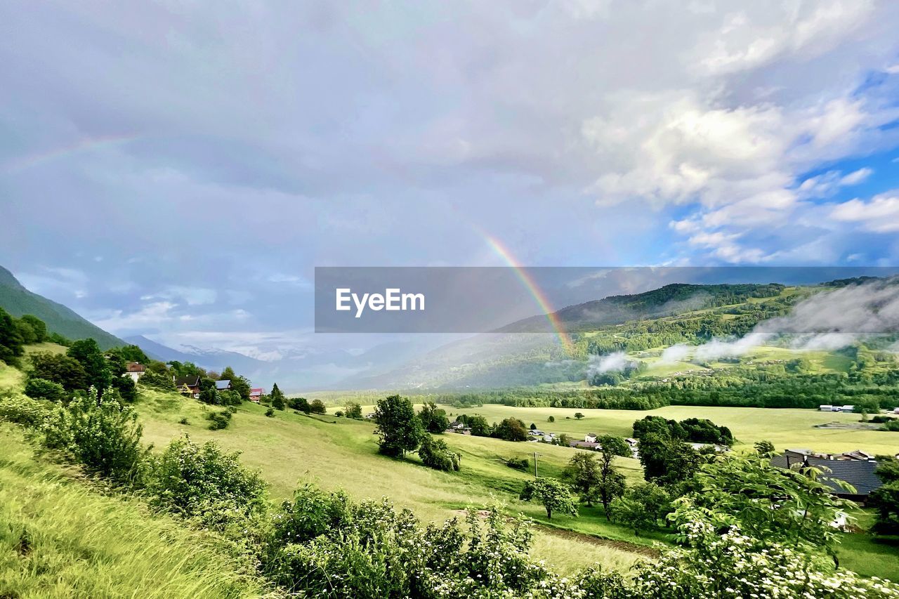 rainbow, environment, scenics - nature, cloud, landscape, sky, beauty in nature, plant, land, nature, hill, green, mountain range, tranquility, tranquil scene, tree, grass, rural area, field, no people, meadow, rural scene, non-urban scene, grassland, idyllic, plateau, valley, water, day, sunlight, outdoors, plain, highland, agriculture, dramatic sky, summer, travel destinations, forest, multi colored, pasture, travel
