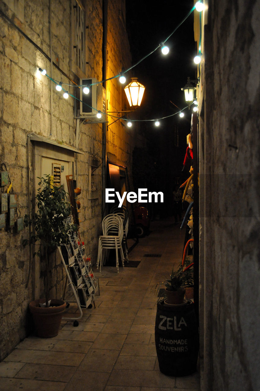 Narrow street amidst old buildings in town at night