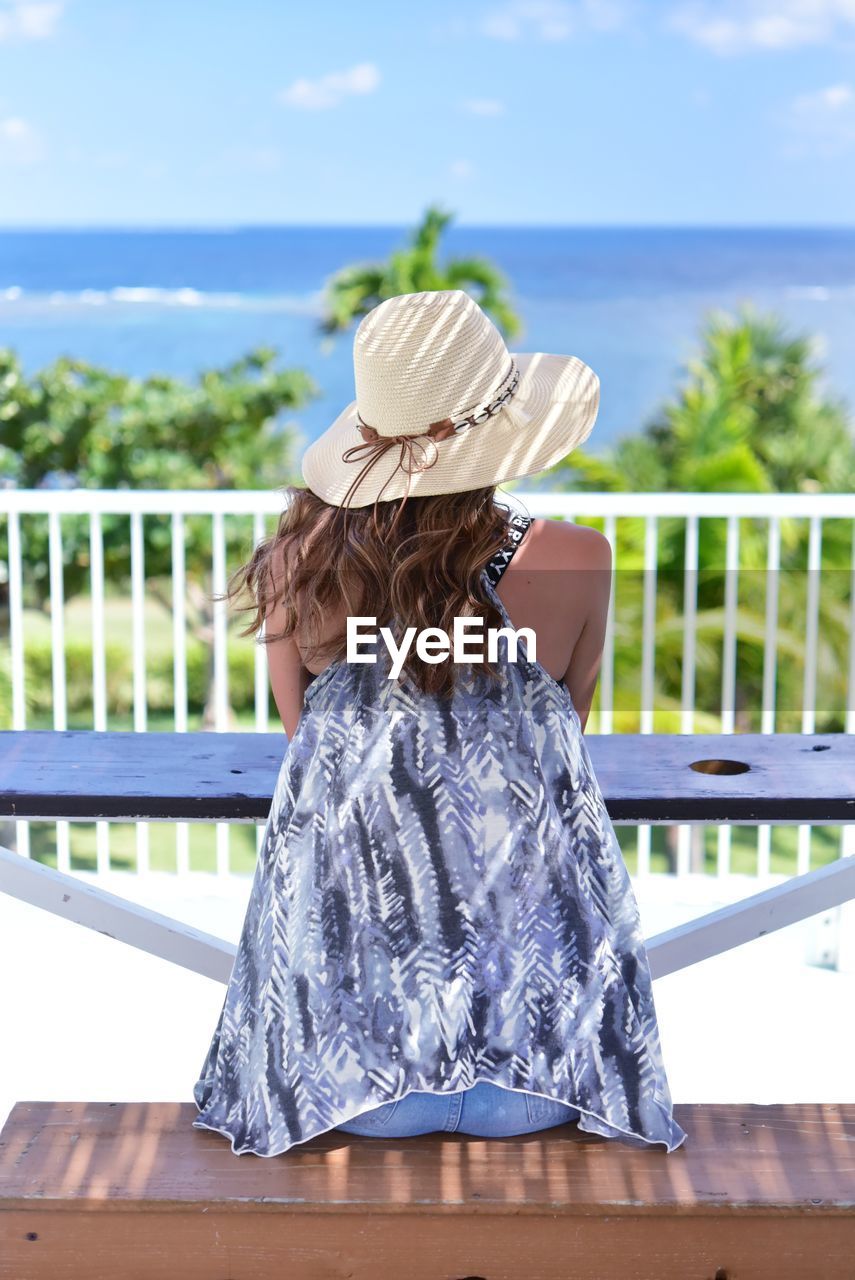 Rear view of girl wearing hat against sea