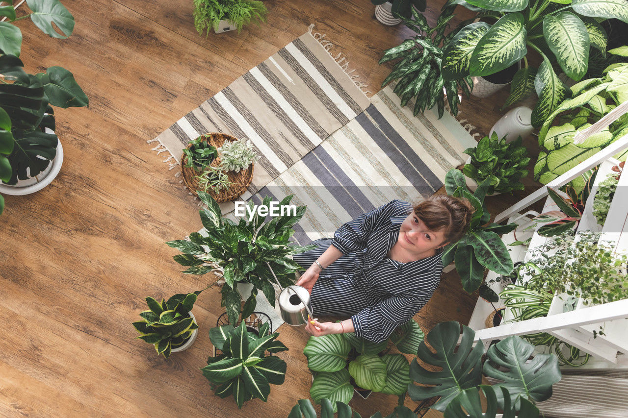 high angle view of woman standing by potted plant
