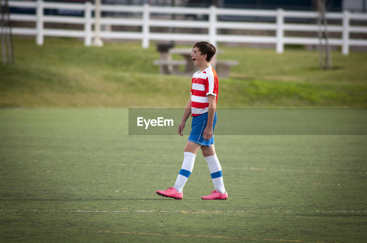 Teen soccer player yawning on the soccer field