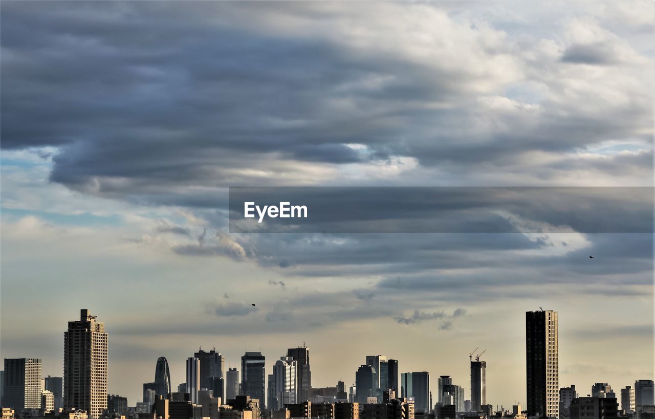 View of cityscape against cloudy sky