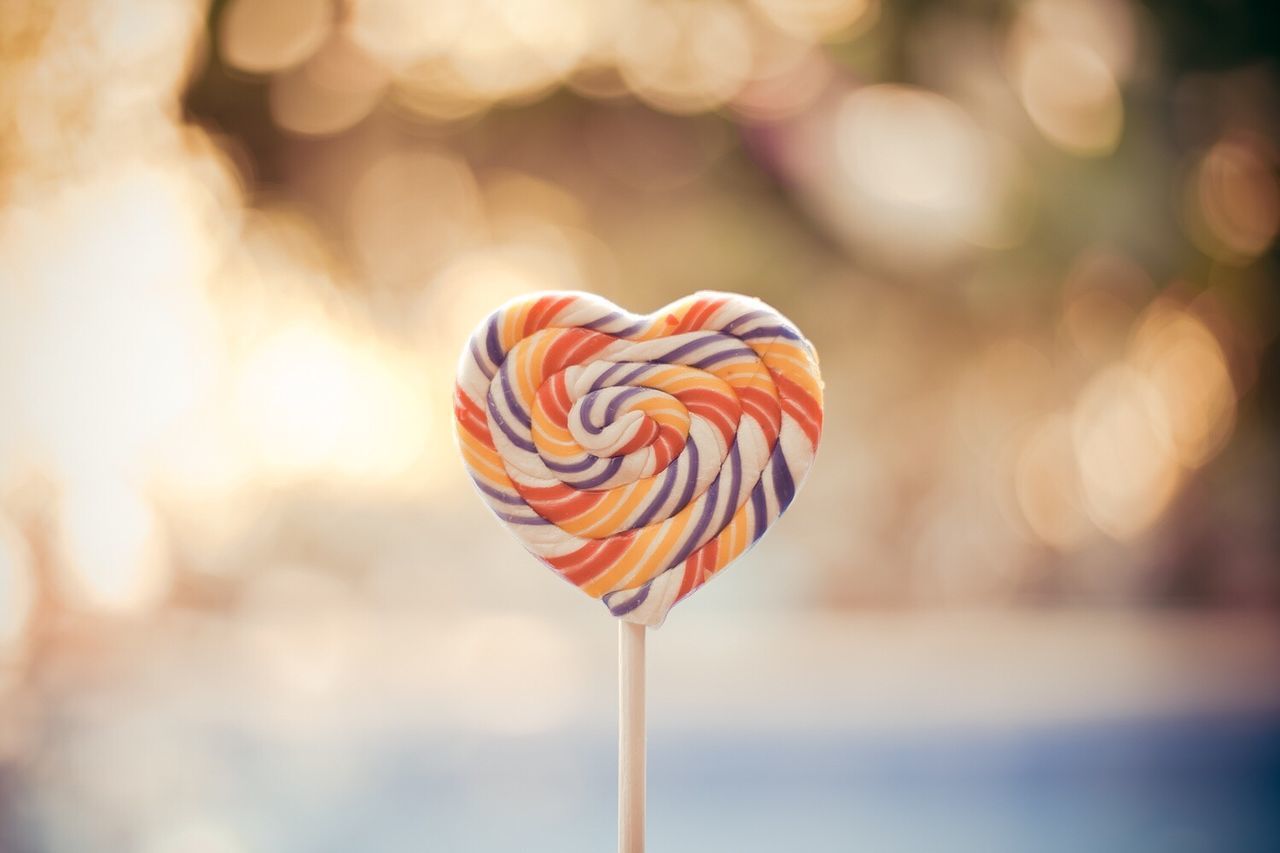 Close-up of heart shaped lollipop against blurred background