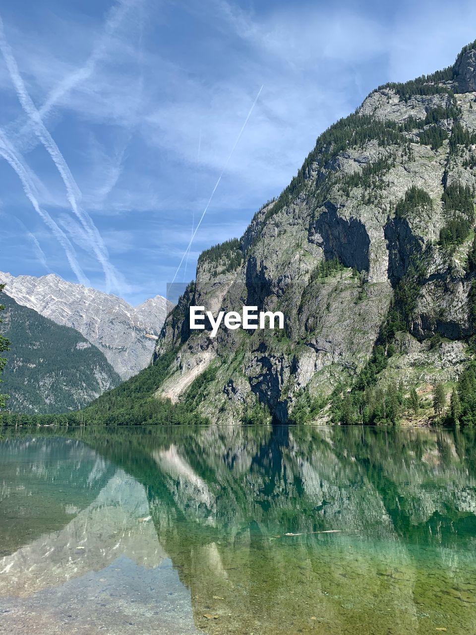 Scenic view of lake by mountains against sky